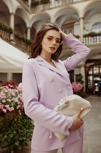 https://media.istockphoto.com/id/1359562499/photo/outdoor-fashion-portrait-of-elegant-woman-wearing-lilac-suit-yellow-sunglasses-holding-trendy.jpg?b=1&s=170667a&w=0&k=20&c=LRMqZQCgreHjaZFUxWlwDGrHpZoJVNAgoxlBDdeWY64=